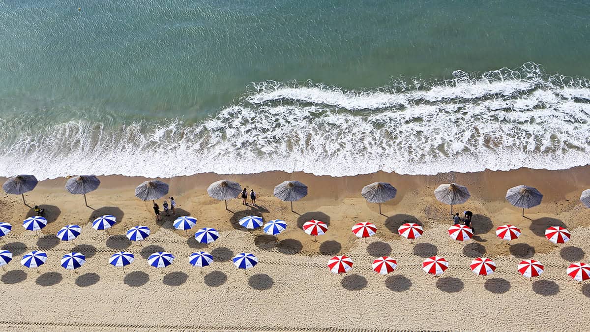 An aerial view of umbrellas and chairs on the beach. An aerial view of umbrellas and chairs on the beach.
